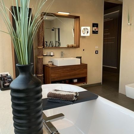 Modernes Badezimmer mit großer Badewanne und großem Spiegel, stilvoll und einladend gestaltet.