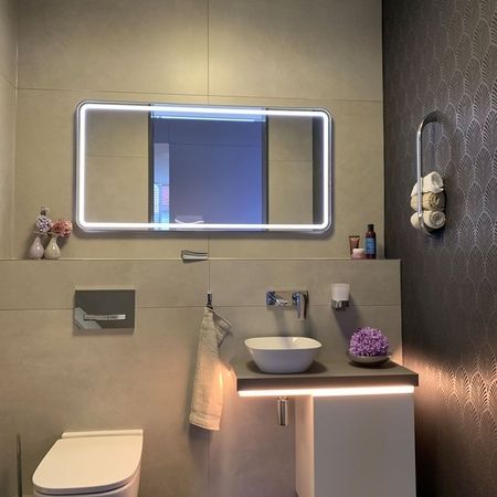 Modernes Badezimmer mit Waschbecken, Toilette und Spiegel, stilvoll und funktional gestaltet.