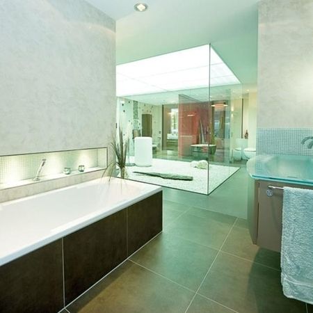 Modernes Badezimmer mit gläserner Dusche und Badewanne, stilvoll und elegant gestaltet.