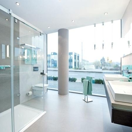 Modernes Badezimmer mit Glastüren für die Dusche und einem eleganten Waschbecken.